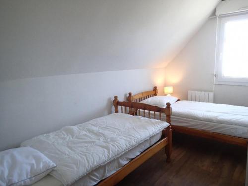 two bunk beds in a room with a window at Étel - Duplex 3 pièces - 42 m² - Piscine - Wifi - Animaux admis - FR-1-479-200 in Étel