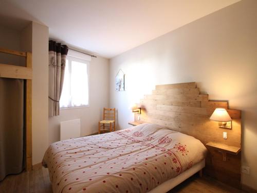 une chambre avec un grand lit avec une tête de lit en bois dans l'établissement Charmant T2 au Mont Dore, 4 pers, Animaux admis, Équipements modernes - FR-1-608-275, à Mont-Dore
