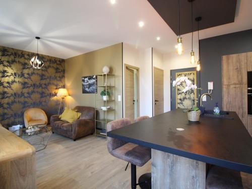 une cuisine et un salon avec une table et des chaises dans l'établissement Appart rénové T2 bis, centre La Bourboule, WiFi, proche thermes - FR-1-608-277, à La Bourboule