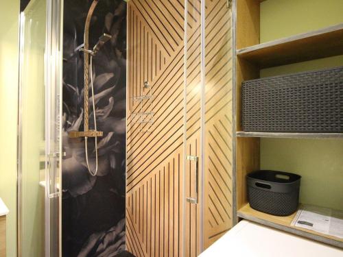 a bathroom with a shower and a wooden closet at Appart rénové T2 bis, centre La Bourboule, WiFi, proche thermes - FR-1-608-277 in La Bourboule