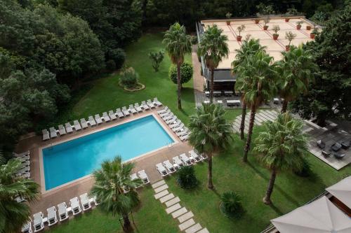an aerial view of a resort with a swimming pool and palm trees at Lisbon Marriott Hotel in Lisbon