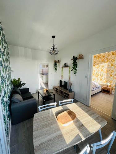 un salon avec une table et un canapé dans l'établissement Les Perles d'Opale - La Belle Etoile, à Boulogne-sur-Mer