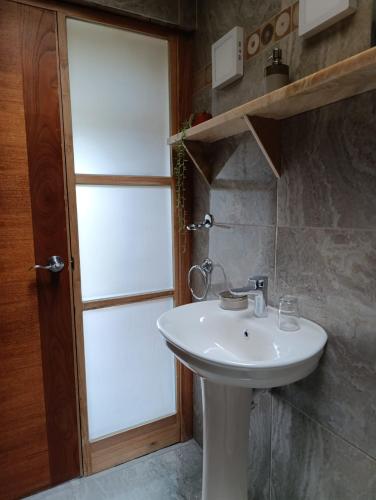 a bathroom with a white sink and a window at Alojamiento Casa Yanantin de Maravilca in Concepción