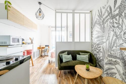 un salon avec une chaise verte et une table dans l'établissement Les Verrières・Studio à 400m de la mer・Netflix, à Saint-Nazaire