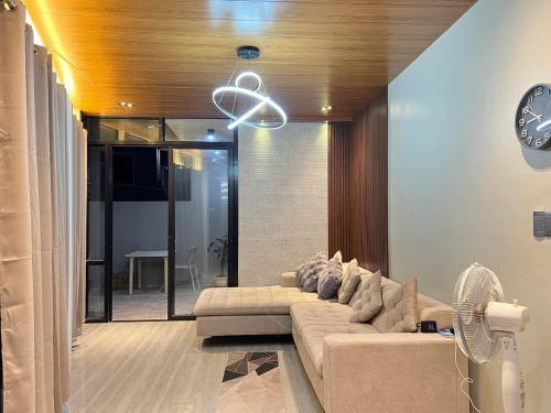 a living room with a couch and a fan at Arrow Hill Vacation House in Dalaguete