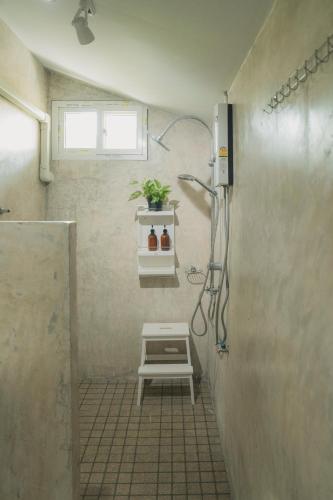 a shower stall with a bench in a bathroom at Baantonmai Farmstay in Ban Mai Ngae
