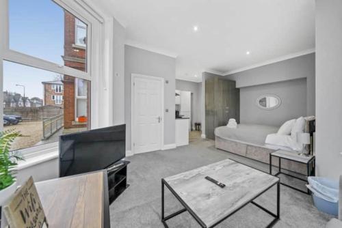 a living room with a bed and a large window at BridgeCity Lovely Studio Apartment Free Parking in Maidstone in Kent