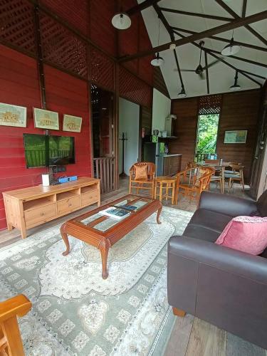 a living room with a couch and a coffee table at Bagas Zakariah Orchard Lodge in Gopeng