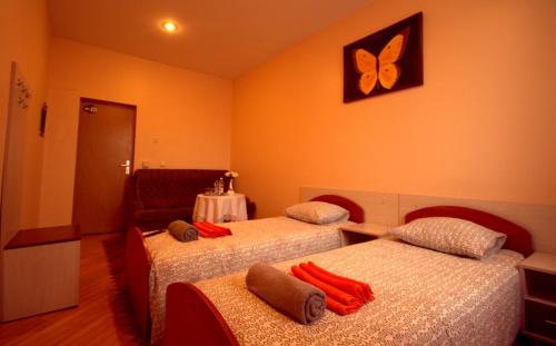 a room with two beds and a butterfly on the wall at Pirčių slėnis in Šniūraičiai