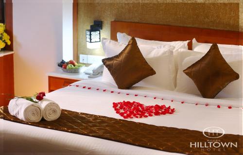 a large bed with red flowers on it at Kgees - Hill Town Hotel in Kattappana