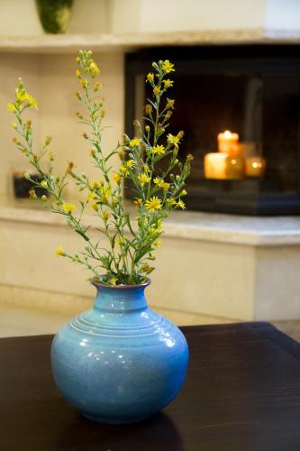 a blue vase with yellow flowers in it on a table at Lycasti Maisonettes in Tavronitis