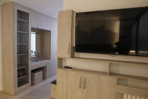 a large entertainment center with a large flat screen tv at Casa El Haje in Al Maşyaf