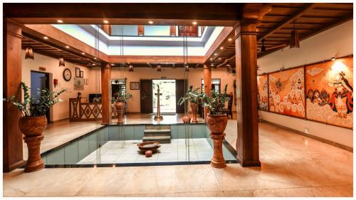 an indoor swimming pool in a house with a lobby at Vajra Ayurveda and Yoga Retreat in Cochin
