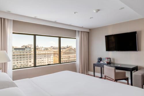 a hotel room with a bed and a desk and a large window at Buenos Aires Marriott in Buenos Aires
