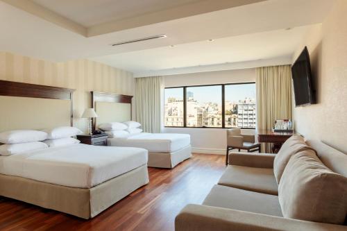 a hotel room with two beds and a couch at Buenos Aires Marriott in Buenos Aires