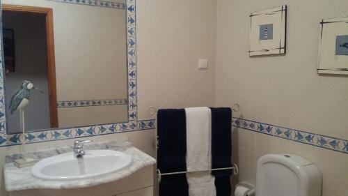 アルブフェイラにあるCasa da Praiaのバスルーム(洗面台、トイレ、鏡付)