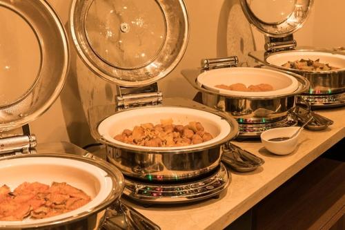 a counter with several pots and pans of food at Hotel Odashima in Morioka