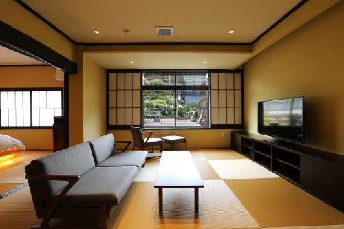 a living room with a couch and a tv at Taikyourou in Miyazu