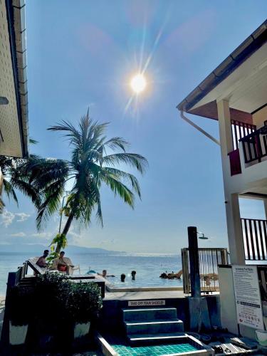 a beach with a palm tree and the ocean at Rin Bay View Resort in Haad Rin