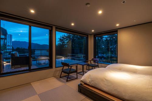 a bedroom with a bed and a balcony with a view at Taikyourou in Miyazu
