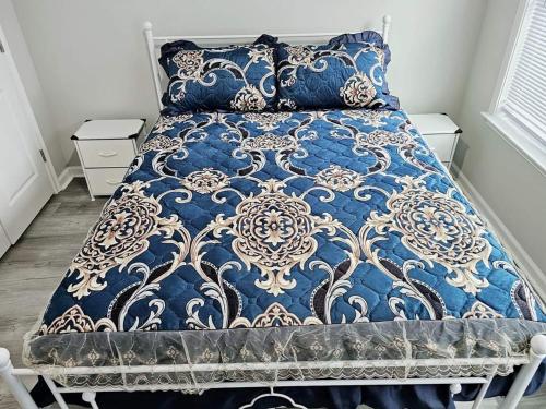 1 cama con edredón y almohadas azules y blancos en Come feel home away from home, en Crawfordville