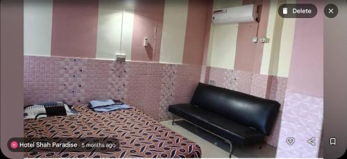 a room with a bed and a black leather bench at Hotel Shah Paradise in Bīrganj