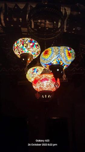 a group of lights hanging from a ceiling at Al Hamra Old House in Al Ḩamrāʼ
