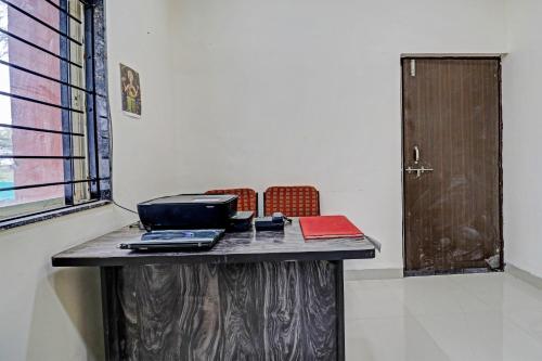 a table with a laptop computer on it with two chairs at Super HOTEL O MIDWAY TREAT DHAR in Dhār