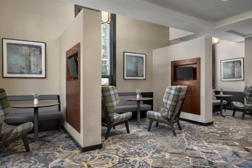a waiting room with tables and chairs and televisions at Residence Inn by Marriott Omaha Downtown Old Market Area in Omaha