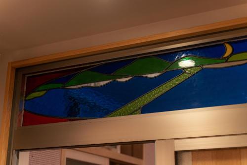 a stained glass window above a windowneauangering at Taikyourou in Miyazu