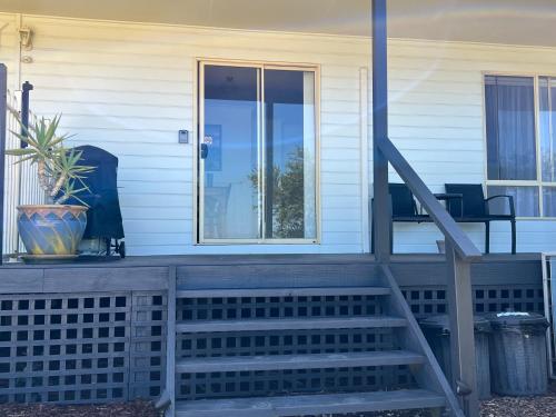 a front porch with a glass door and stairs at Promhills Cabins in Yanakie