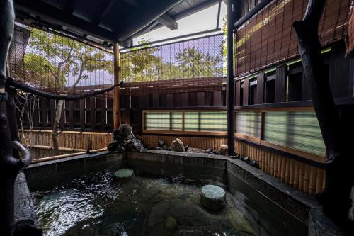 a pond in front of a building with a house at Taikyourou in Miyazu