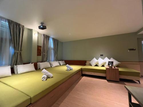 a room with a large yellow bed with pillows at Swiss Hotel Heritage Boutique Melaka in Melaka