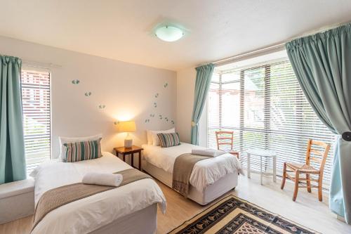 une chambre avec deux lits et une fenêtre dans l'établissement Central Wilderness Bliss - Sleeps 6 - Beach & Lagoon, à Wilderness