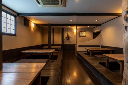 a dining room with wooden tables and benches at Taikyourou in Miyazu