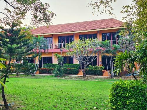 a house with a lawn in front of it at Pranmanee Beach Resort in Sam Roi Yot