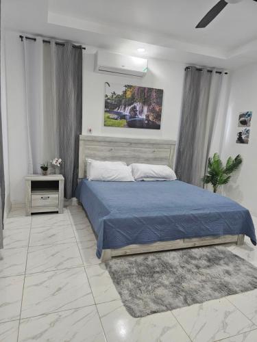 a bedroom with a bed with a blue comforter at Blanco Oasis in Banks