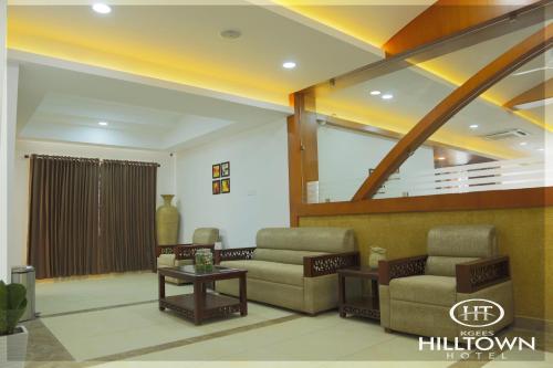 a living room with two couches and a table at Kgees - Hill Town Hotel in Kattappana
