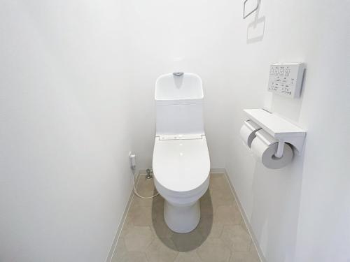 a white bathroom with a toilet and a sink at 肴町街舎 in Hamamatsu