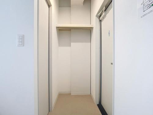 a hallway with white walls and a white closet at 肴町街舎 in Hamamatsu