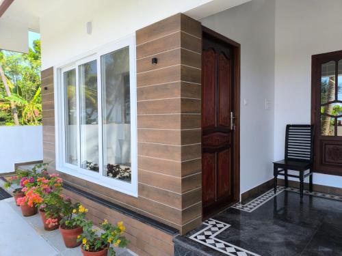 a front door of a house with potted plants at Sea Breeze Cherai Homestay in Pallipuram