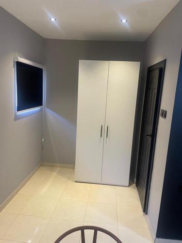 a room with a white cabinet and a window at Tropical Enclave Apartment Osu in Accra