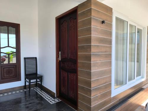 a wooden door in a room with a window at Sea Breeze Cherai Homestay in Pallipuram