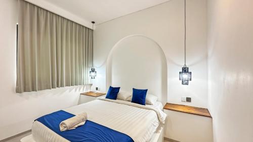 a bedroom with a large bed with blue pillows at Samastiti Bingin in Uluwatu