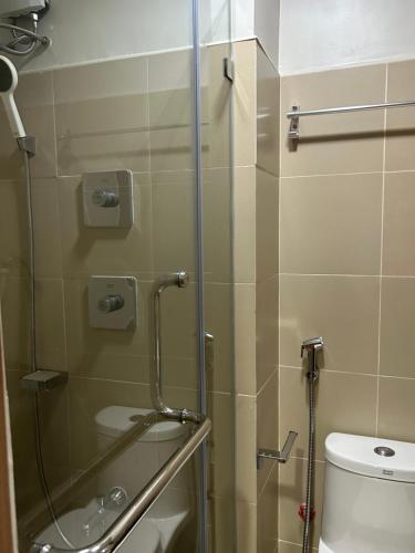a bathroom with a shower and a toilet at JN Staycation at Shore 3 Mall of Asia in Manila
