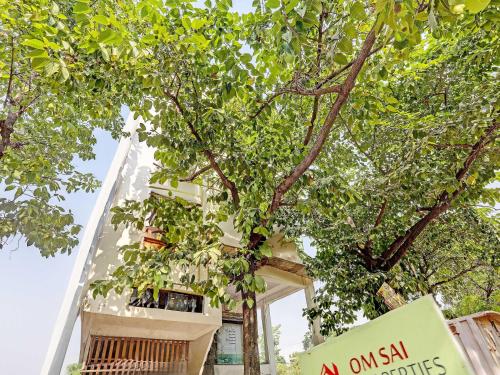 a building with a sign in front of a tree at Super Hotel O Park Inn Near Parashuram Chowk in Morādābād