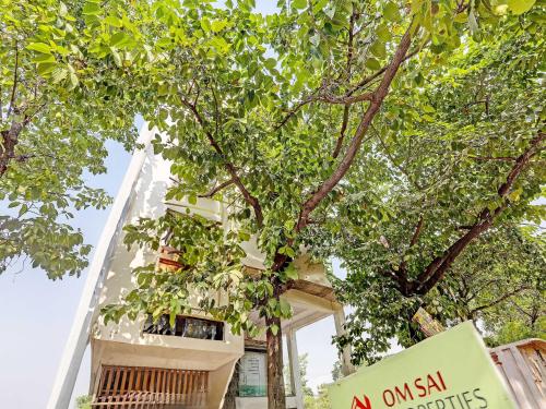 a building with a sign in front of a tree at Super Hotel O Park Inn Near Parashuram Chowk in Morādābād
