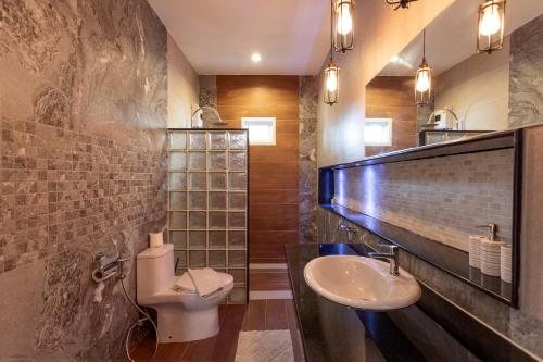 a bathroom with a sink and a toilet at Karon Bliss: 4 Bedroom Haven in Karon Beach