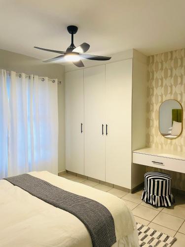 a bedroom with a bed and a ceiling fan at Atlantis Luxe escape Unit 25 in Uvongo Beach