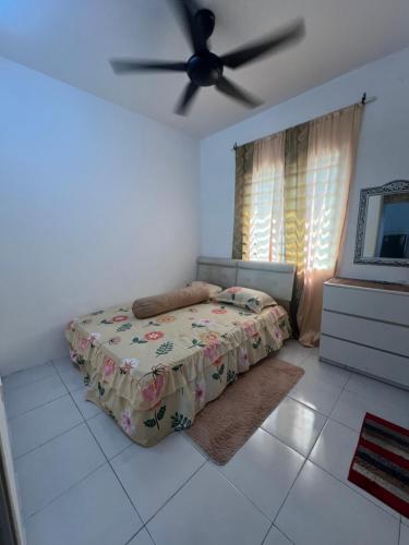a bedroom with a bed and a ceiling fan at FA Homestay in Pusing